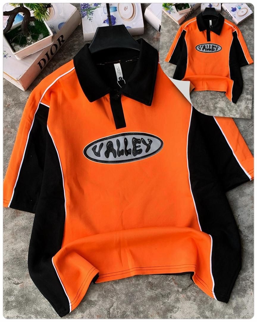 Orange long sleeve zip collar polo with black sleeves, white trim and Valley logo on chest.