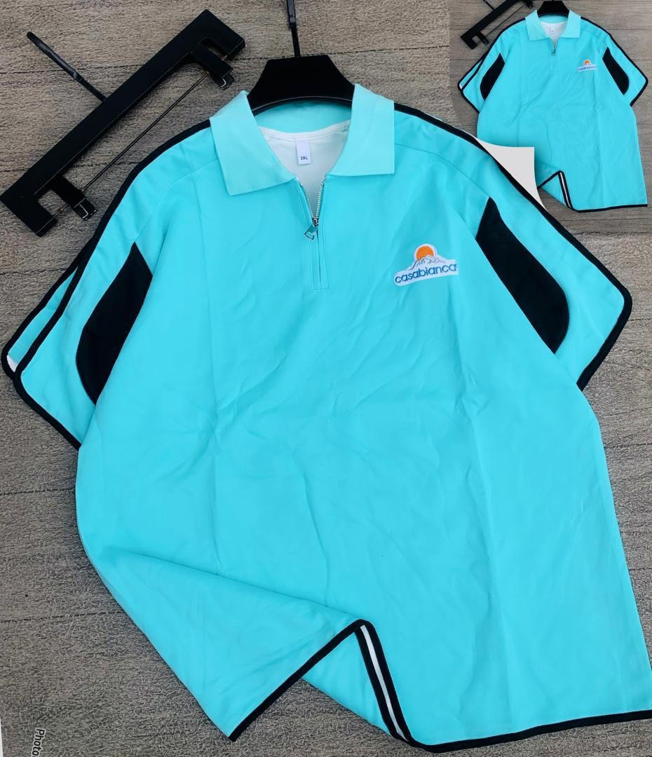 Light blue long sleeve zip collar polo shirt with black panels and Casablanca embroidery on the chest.