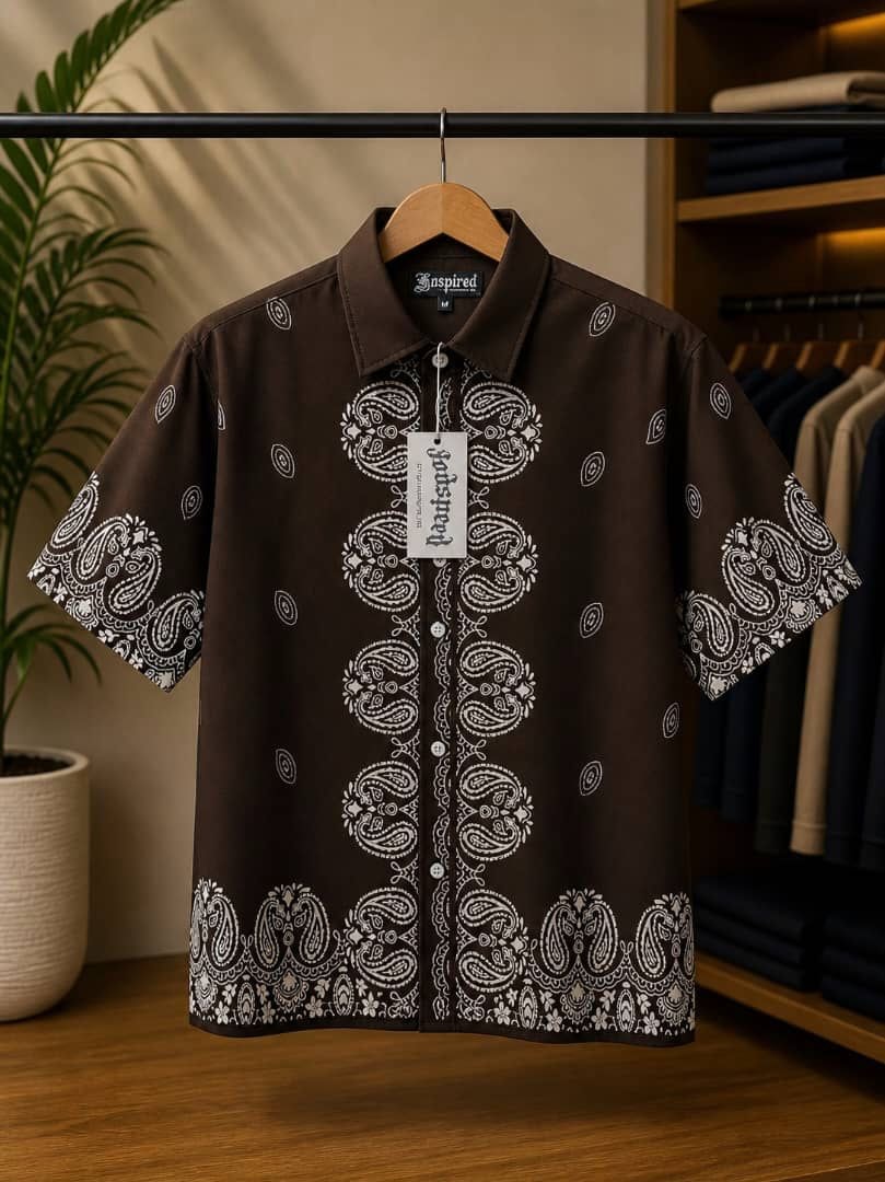 Brown short sleeve shirt with white paisley pattern on hanger.