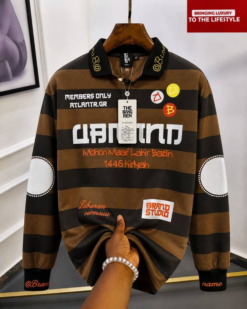 Brown and black striped long sleeve polo with black collar and multiple graphic prints.