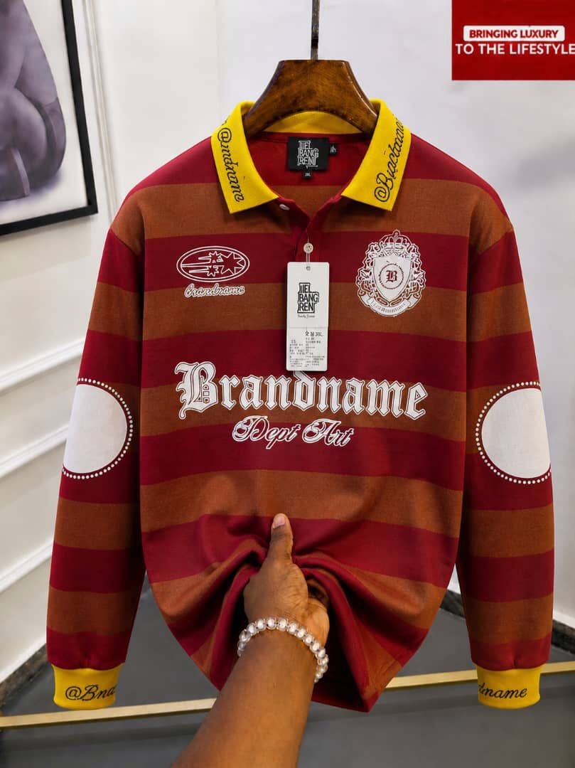 Red and brown striped long sleeve polo with yellow collar and Brandname embroidery.