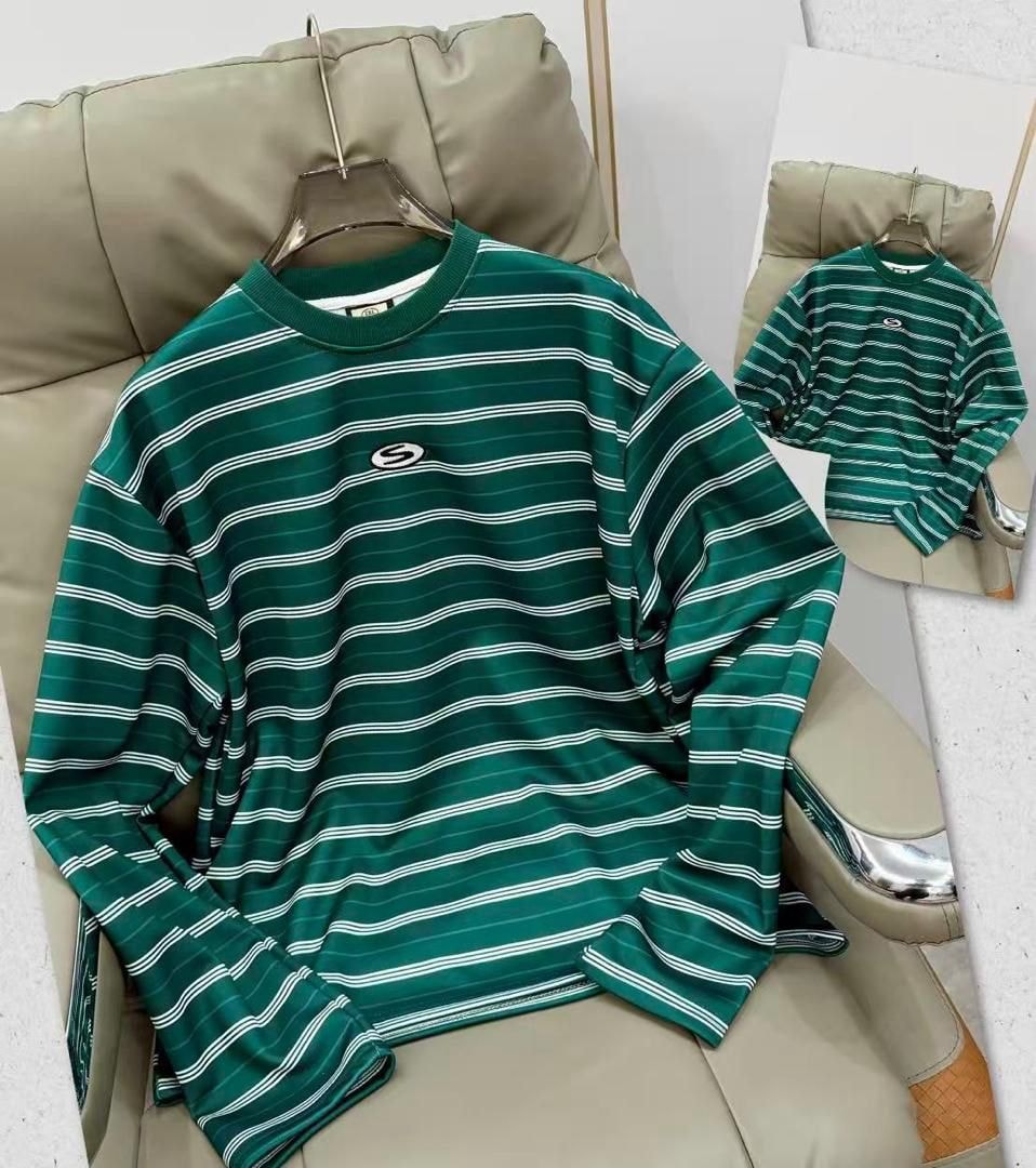 Green striped long sleeve top with white horizontal lines and chest logo on hanger.