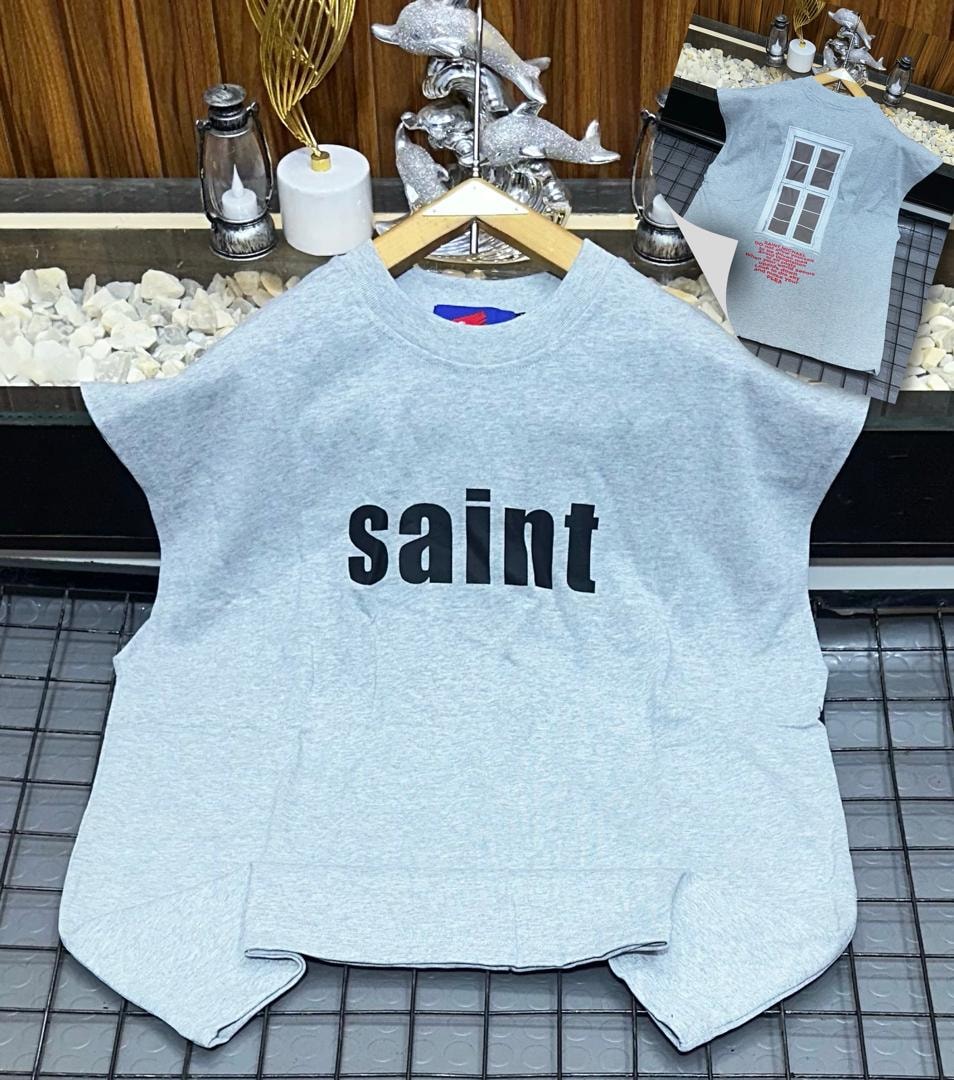 Light grey oversized armless top with black saint text print on chest.