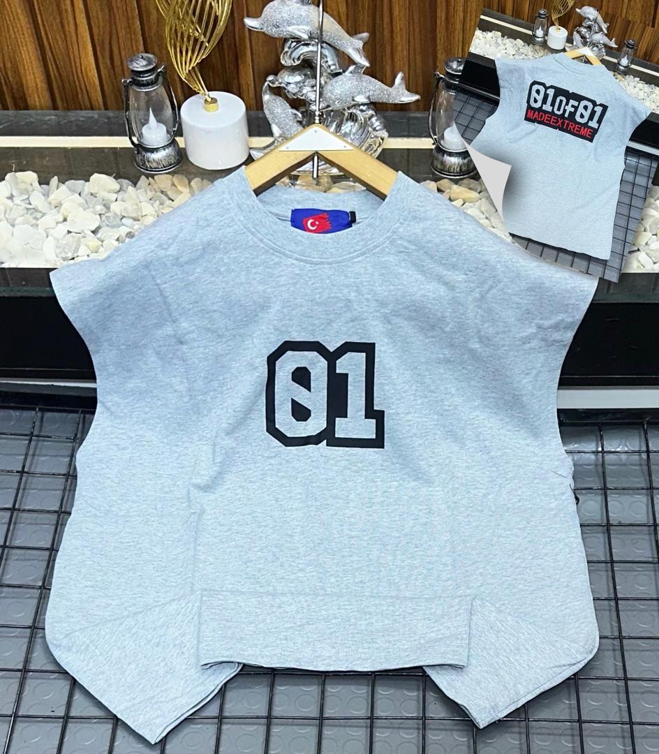 Light grey oversized armless top with large black 01 graphic on chest.