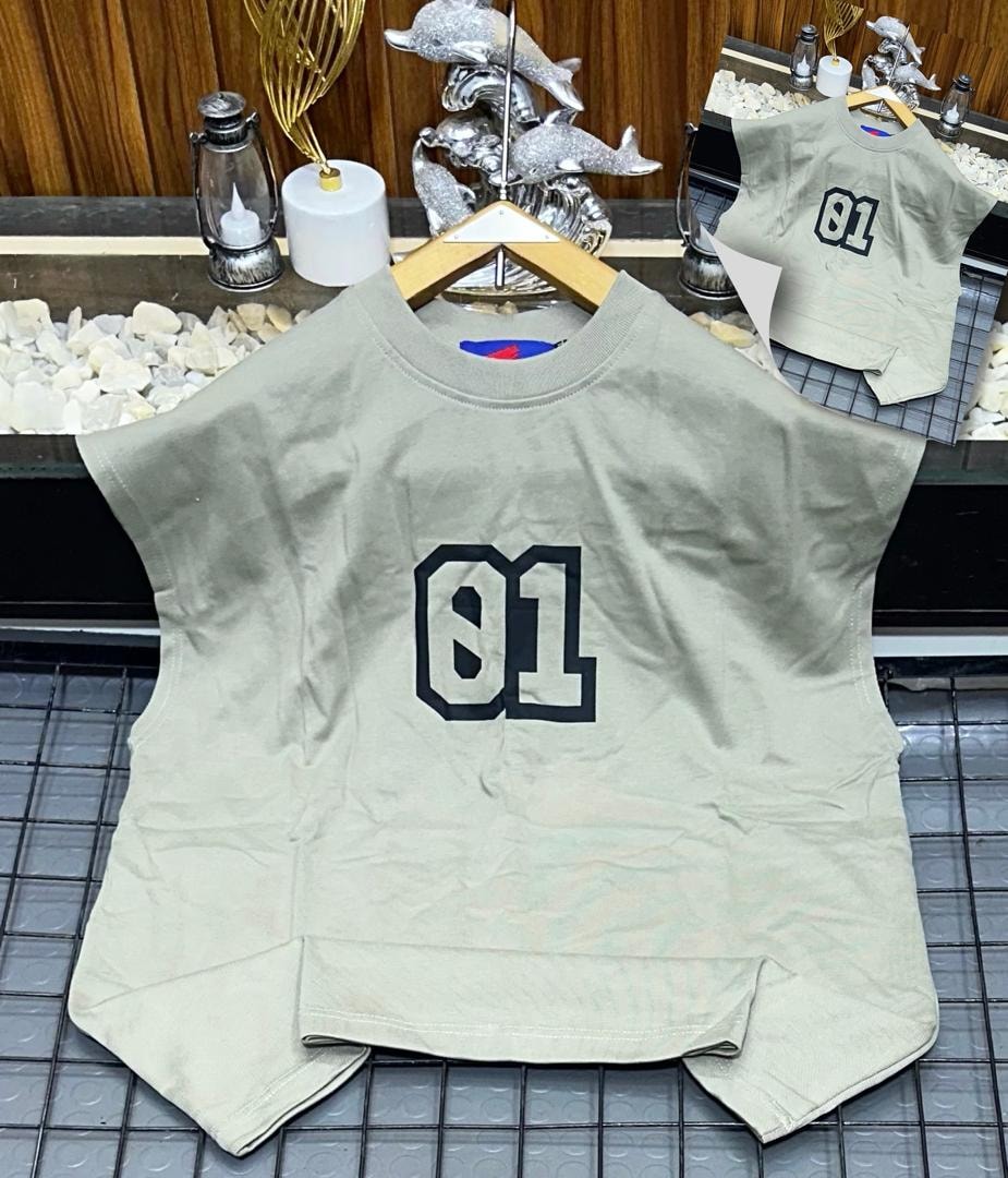 Beige oversized armless top with large black 01 graphic on chest.