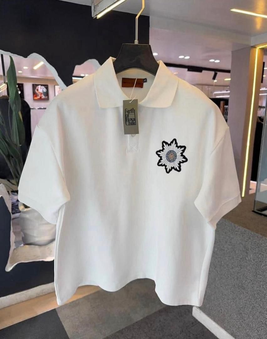 White short-sleeve polo shirt with chest embroidery hanging in store.