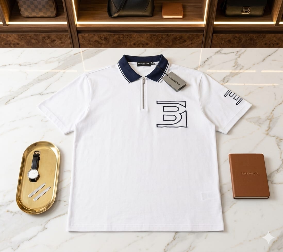 White polo shirt with large B logo, zipper neck, and navy collar laid flat.