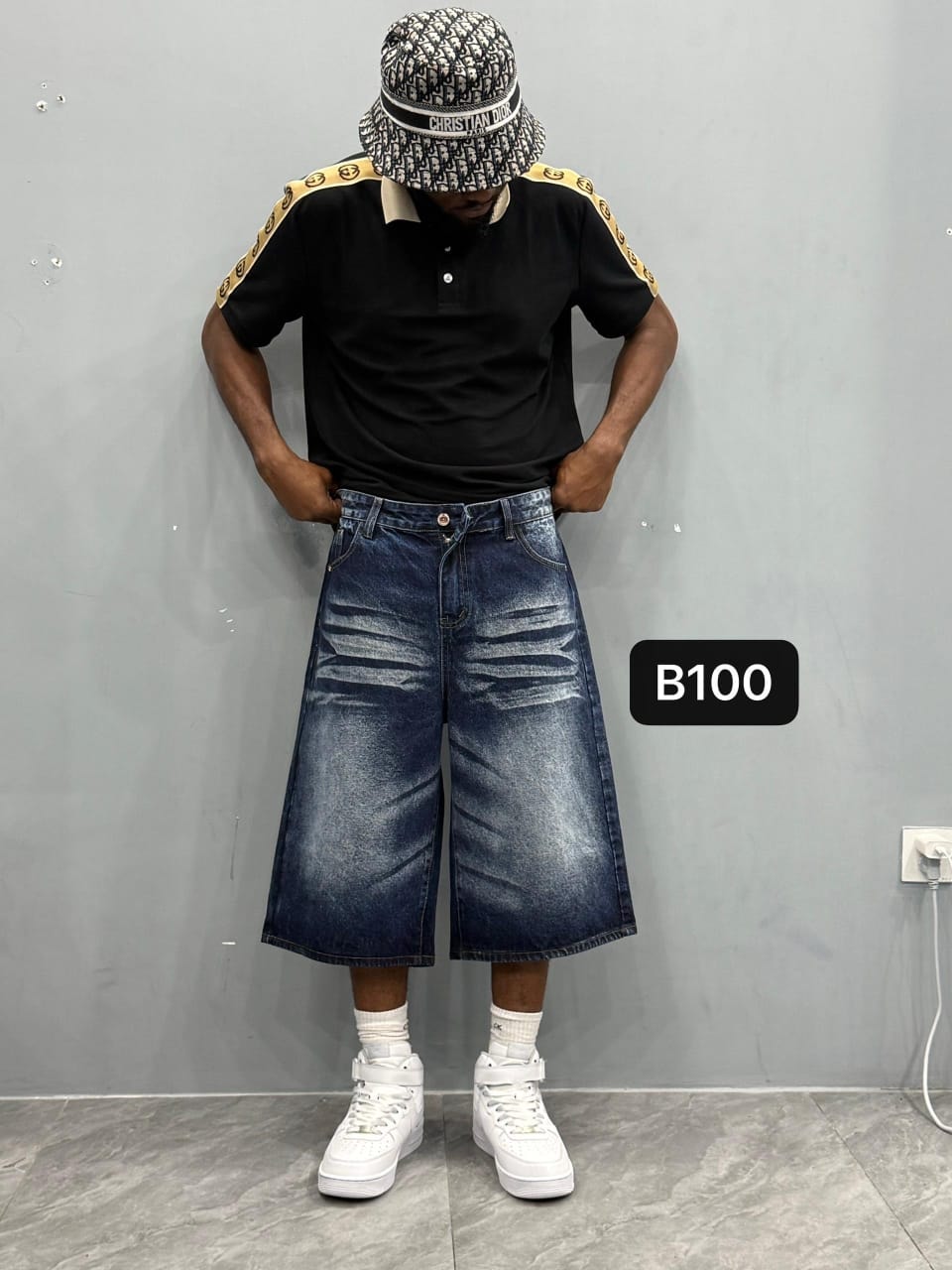 Model wearing navy 3/4 denim shorts with black polo.
