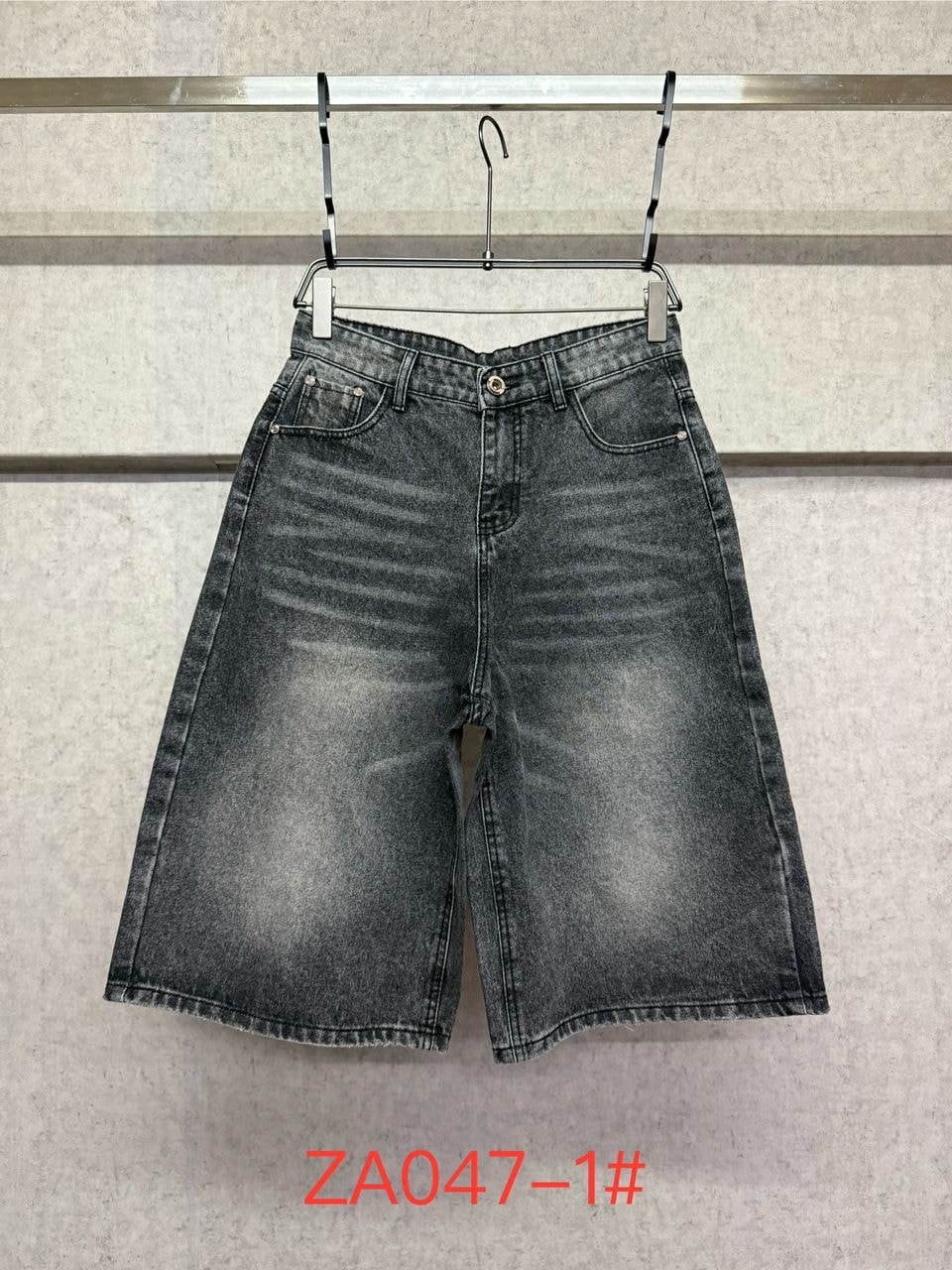 Flat lay of gray 3/4 denim shorts on a hanger.