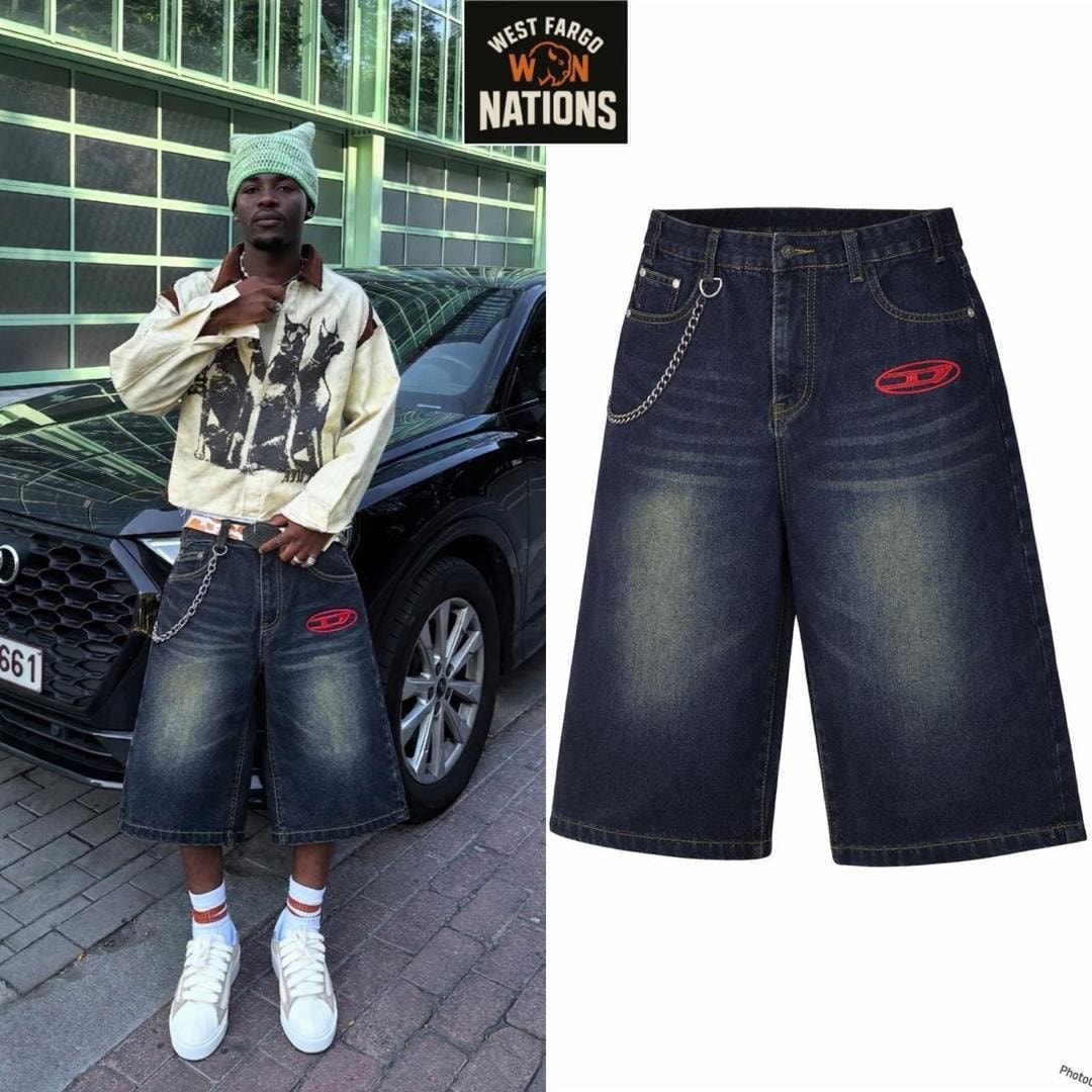 Model in casual jacket wearing the same navy blue denim 3/4 length jorts with chain accessory.