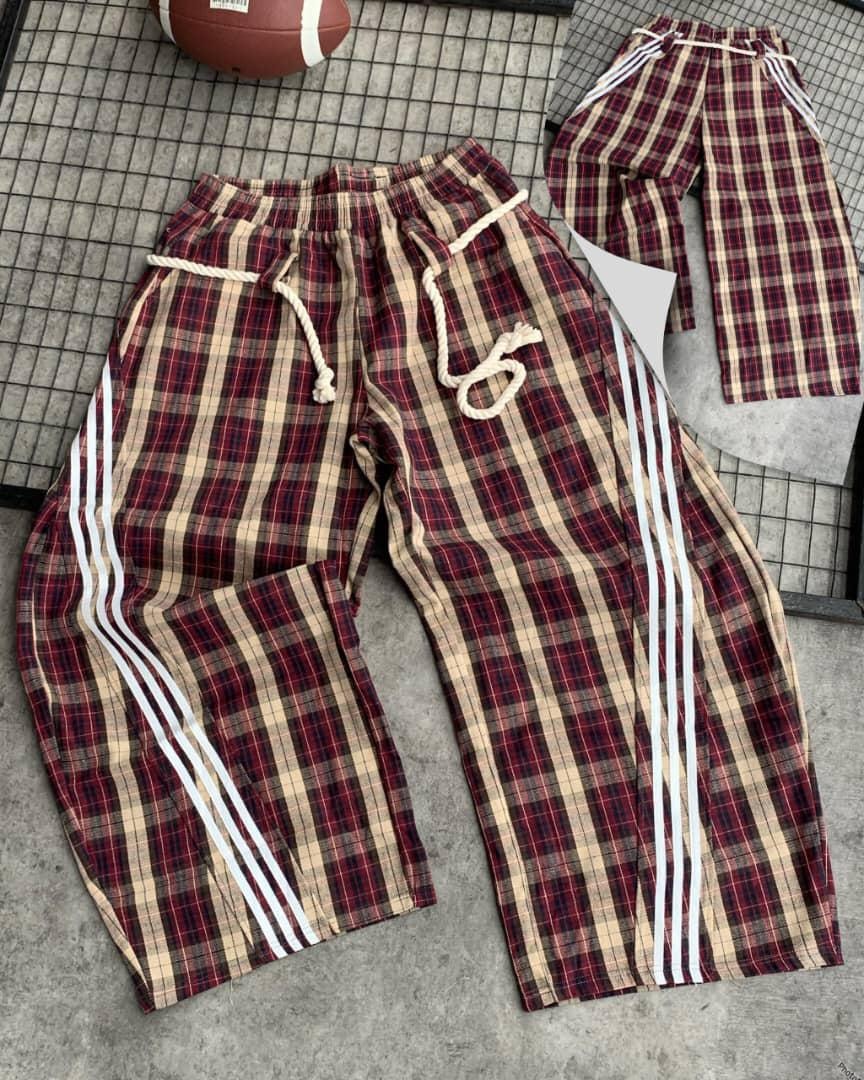 Red plaid checkered joggers with thick white rope drawstring, elastic waist, and three white side stripes.