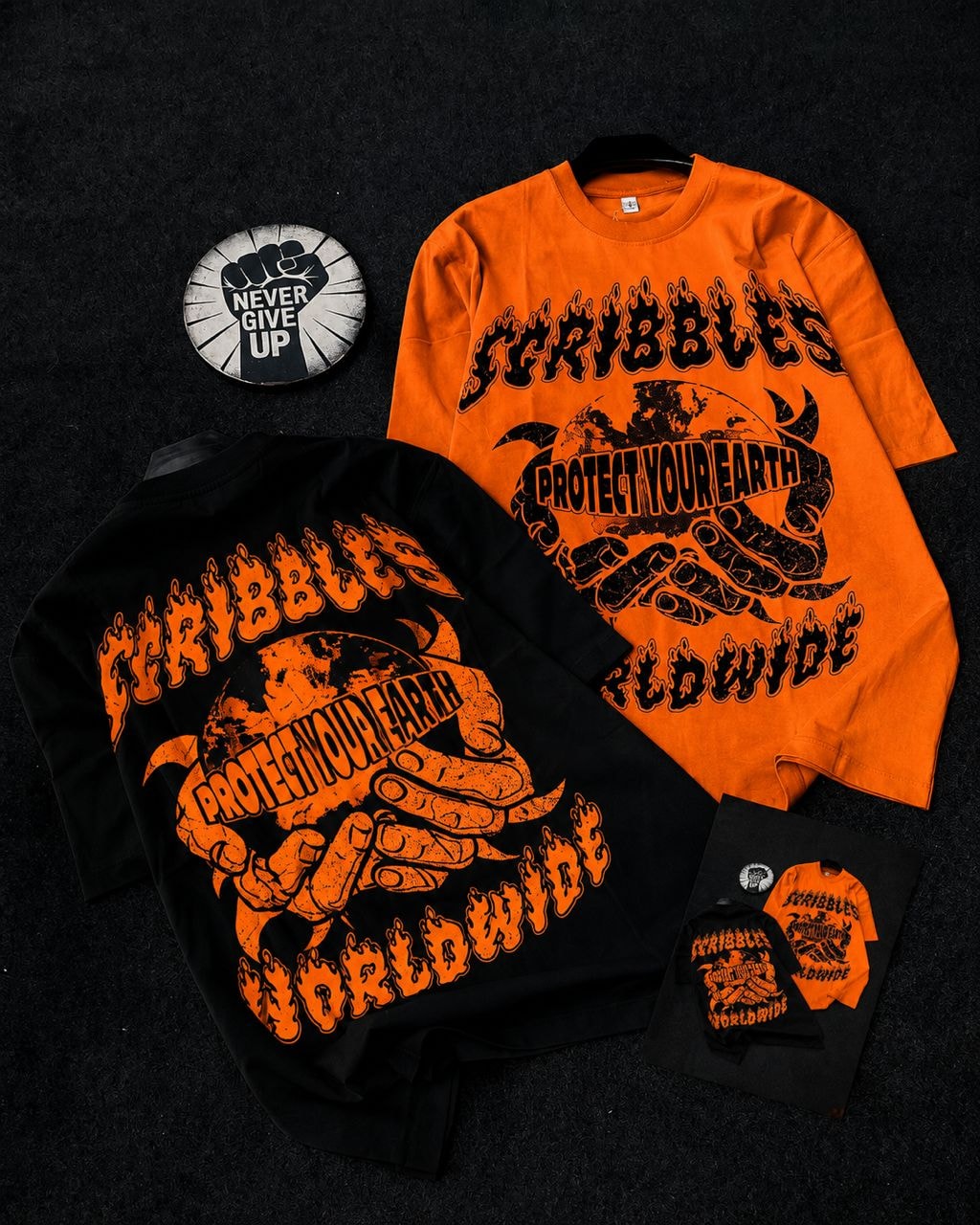 Black and orange t-shirts showing Scribbles earth and hands design in multiple angles.