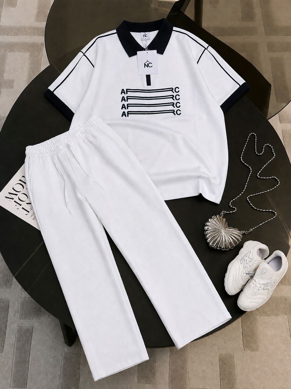 White AFRC polo shirt with black contrast trim and matching white trousers.
