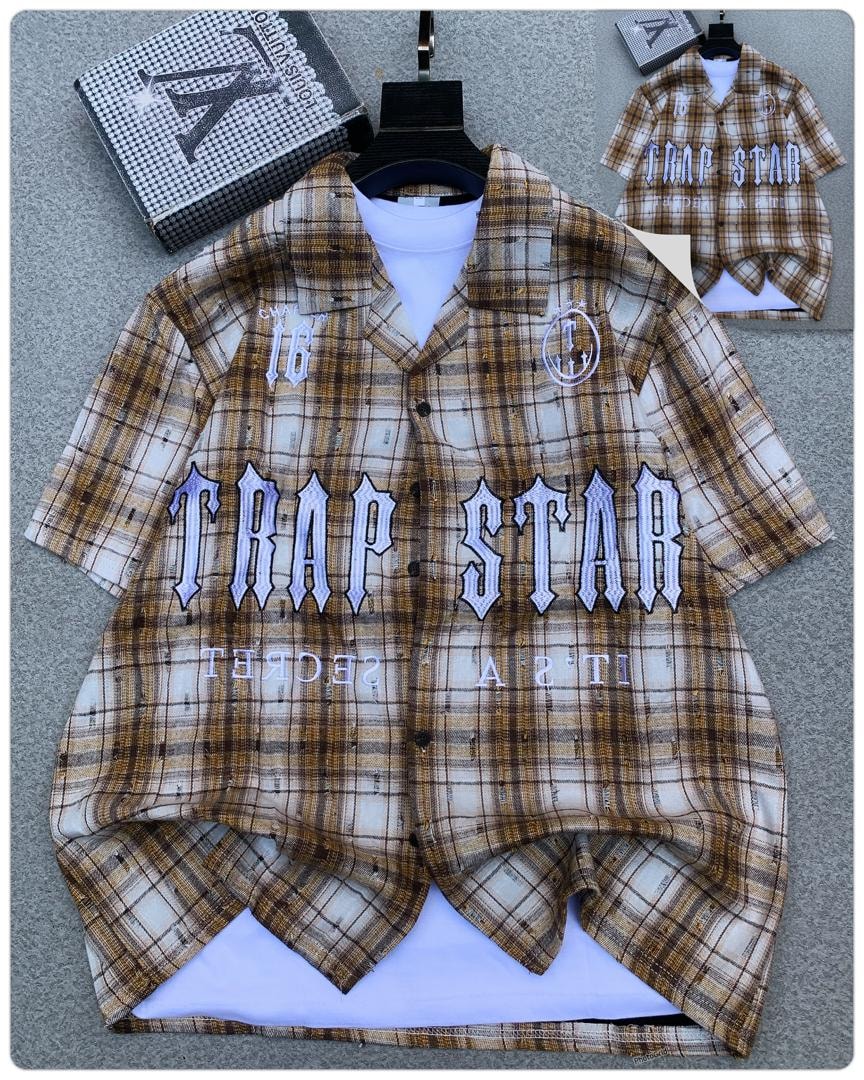 Brown plaid Trapstar short sleeve shirt displayed flat with embroidery and branded box.