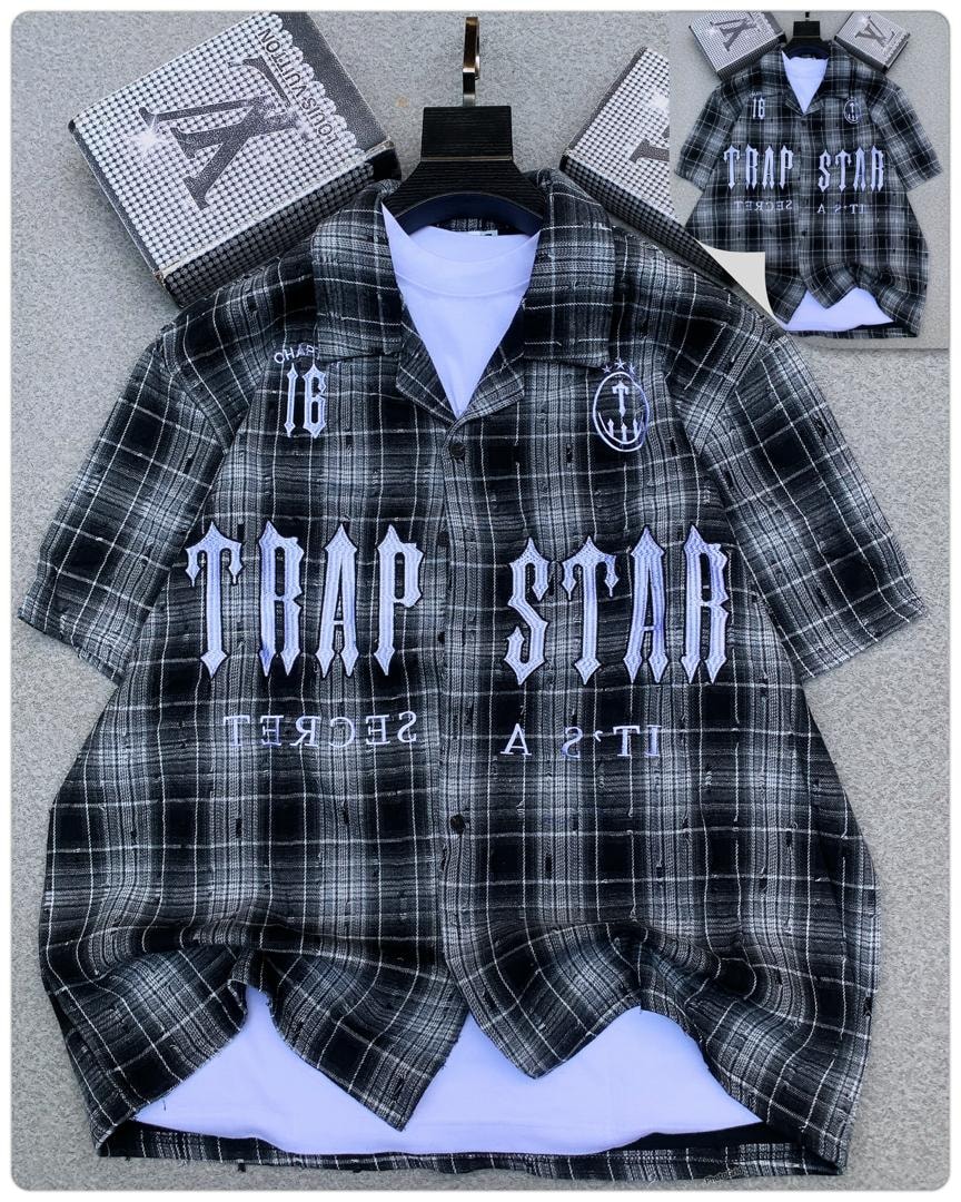 Black plaid Trapstar button-up shirt showing chest logos, plaid pattern and white undershirt.