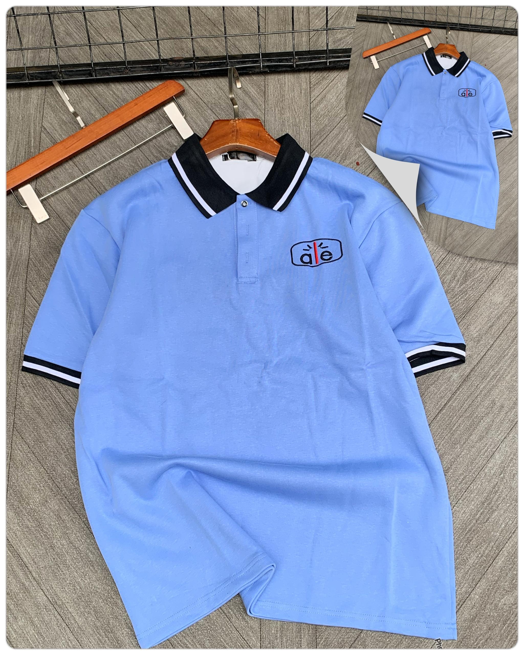 Light blue short sleeve polo with black contrast collar and logo detail.
