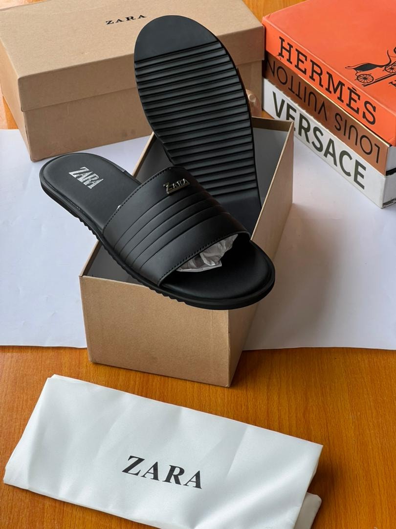 Black Zara ribbed slides in branded box with dust bag on wooden surface.