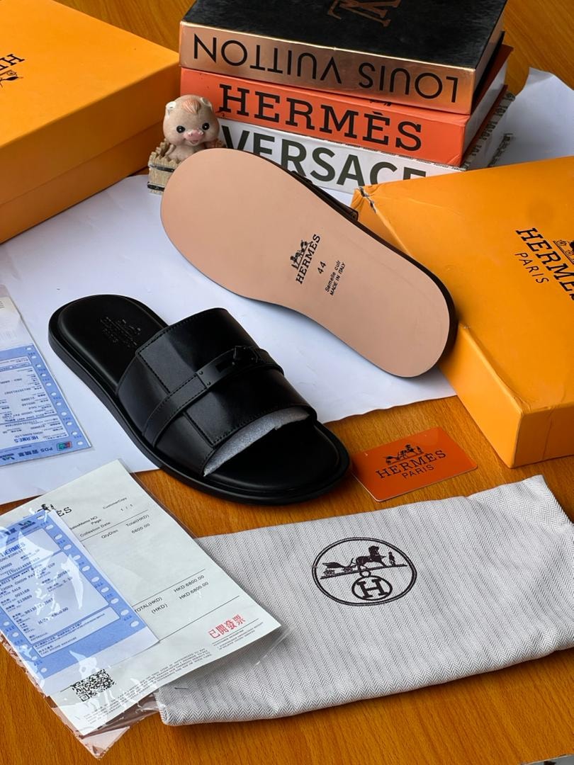 Black Hermès buckle slides shown from sole with luxury boxes, dust bag and documents.