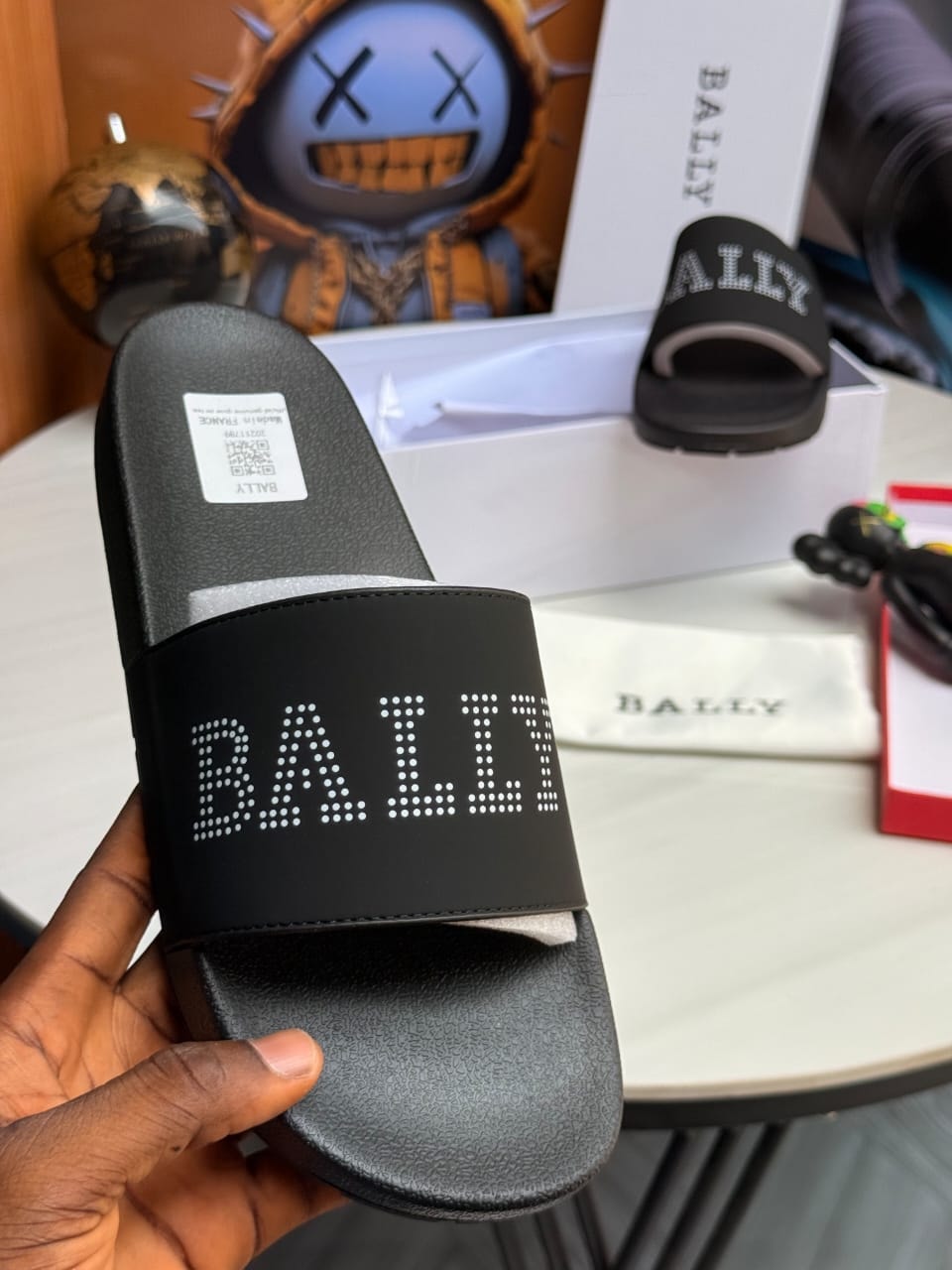 Black Bally slides with dotted BALLY text logo on strap.