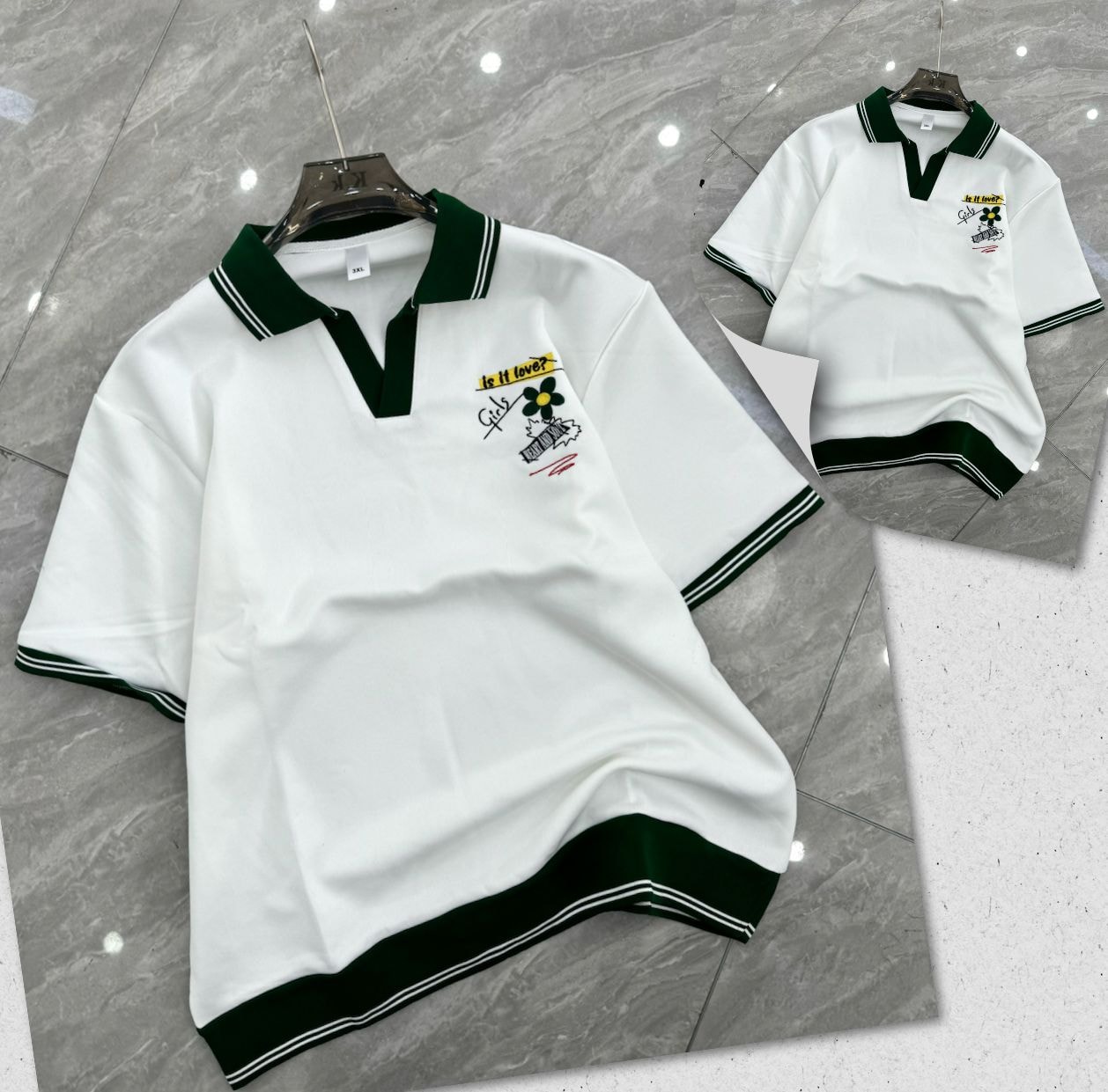 White polo shirt with dark green trim and chest embroidery on hanger and flat lay.