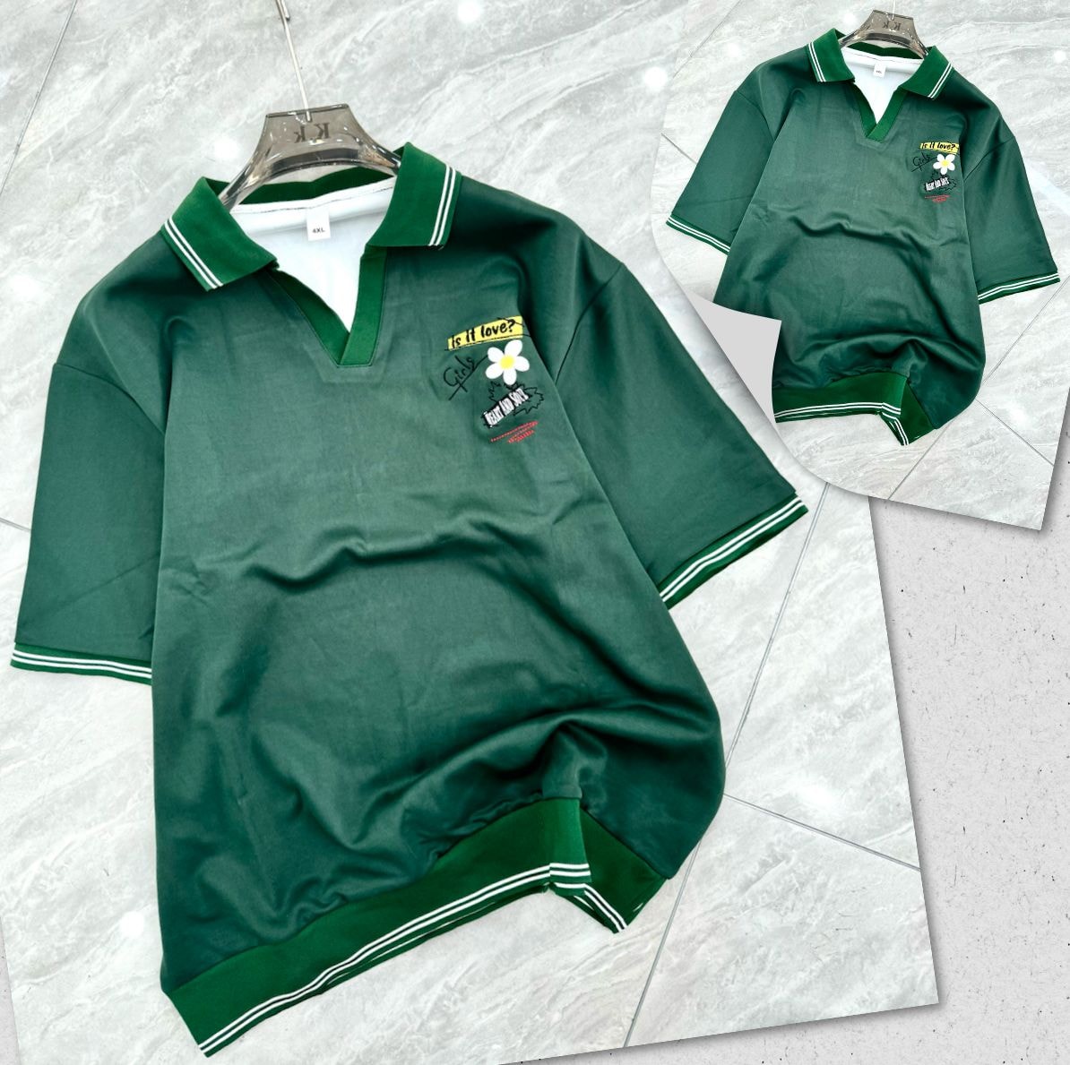 Green polo shirt with green trim and chest embroidery on hanger and flat lay.