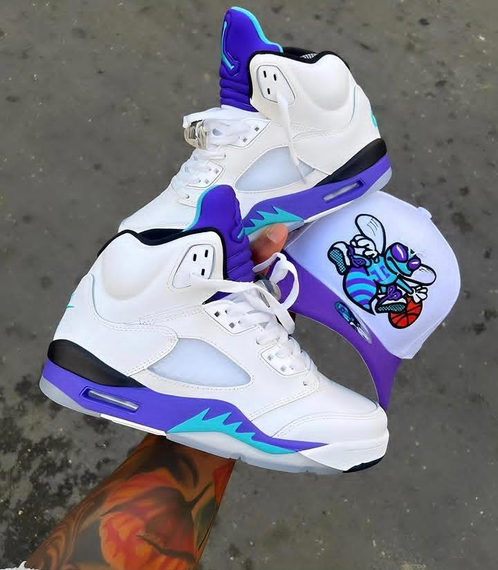 White high-top sneakers with purple and turquoise accents shown with matching graphic cap.