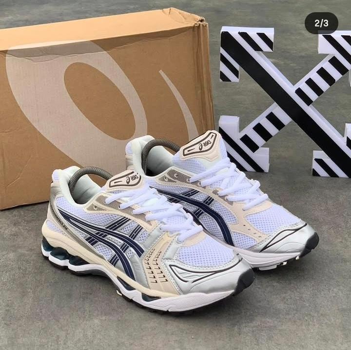 Pair of Asics white navy sneakers with beige accents and mesh upper shown with branding visible