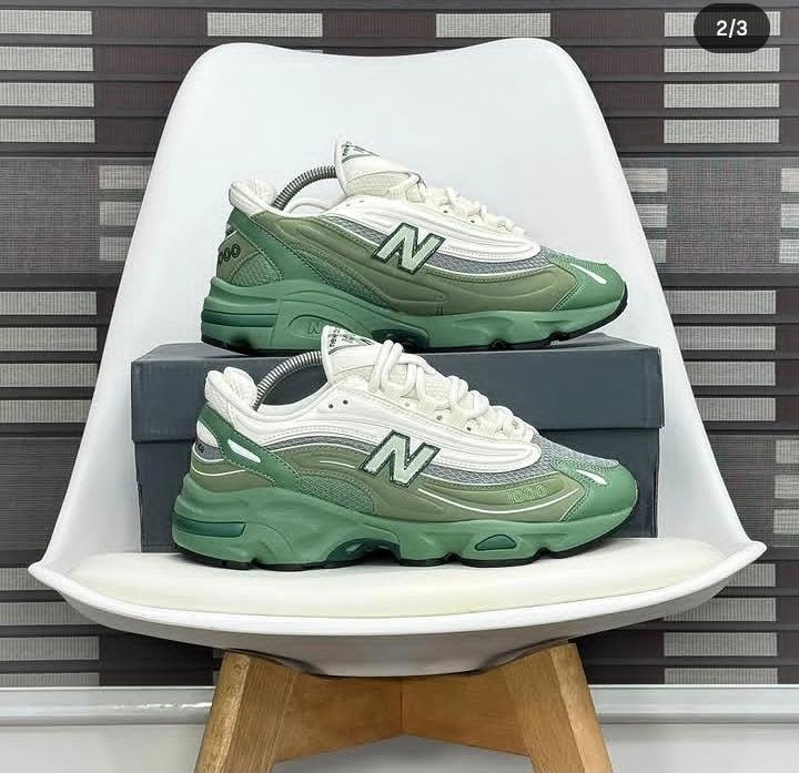New Balance 1000 sneakers in green and white colorway displayed on box.