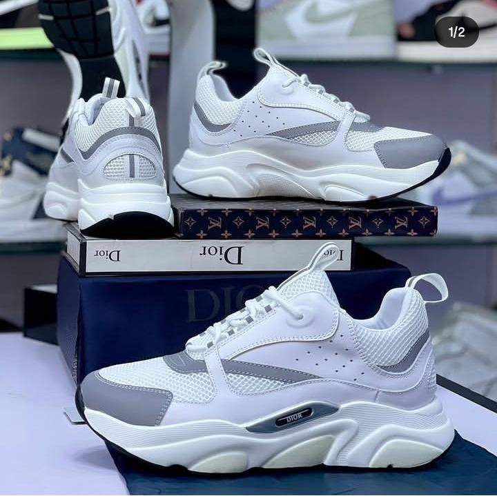 White and gray Dior sneakers displayed from multiple angles with chunky sole and branding visible.