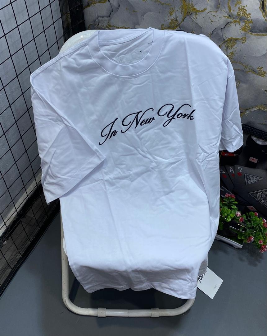 White t-shirt with black cursive In New York text print across chest.