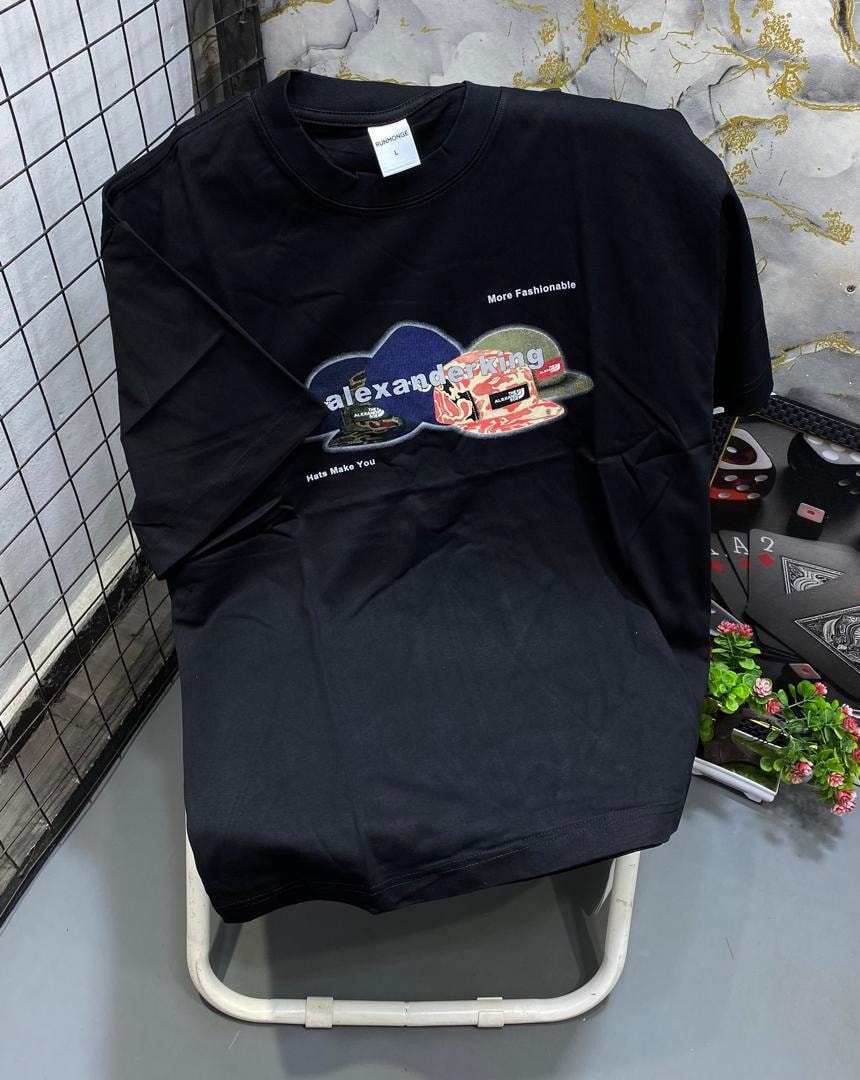 Black t-shirt with colorful Alexanderking graphic featuring hats and text slogans.