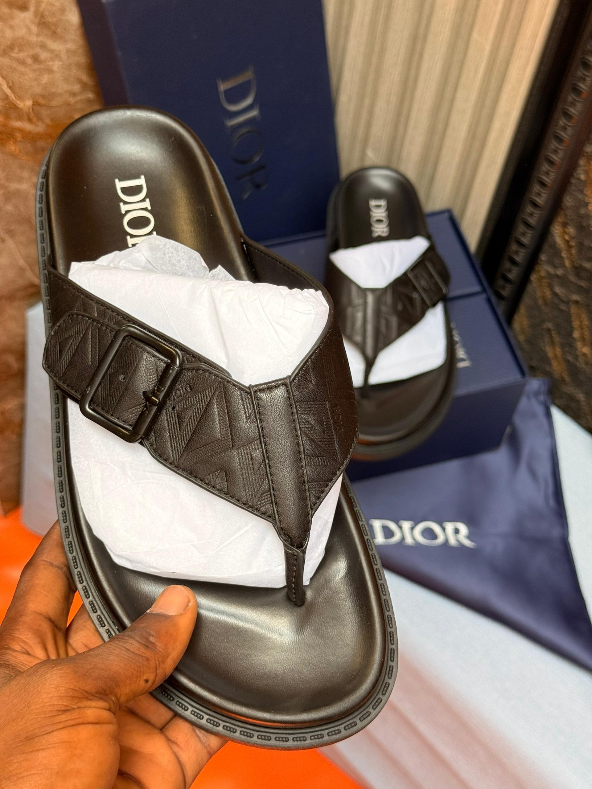 Brown Dior monogram leather slides with buckle strap and logo insole.