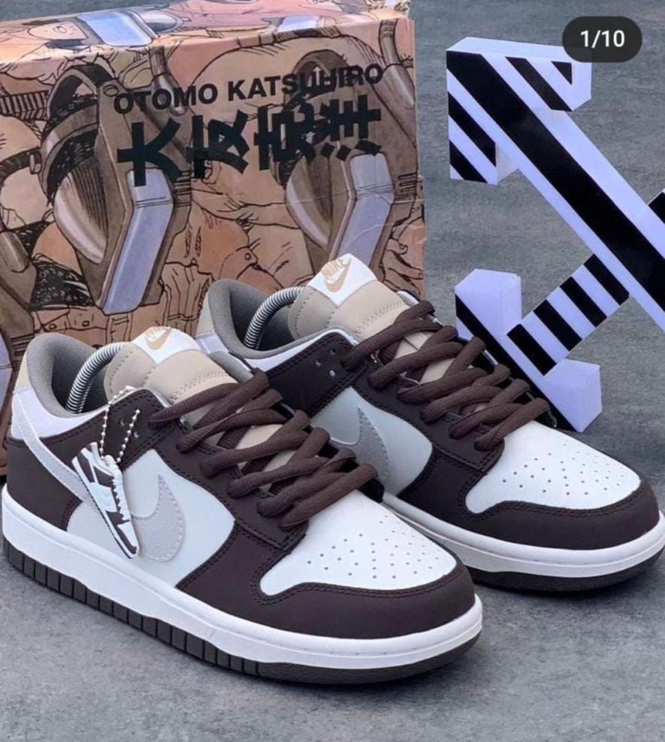 Nike Dunk Low sneakers in brown, white and grey with illustrated shoebox and geometric props in background.