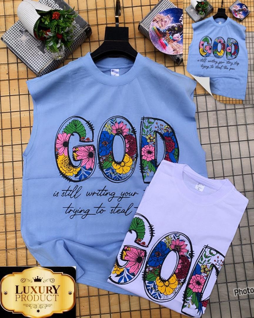 Light blue and purple armless tees displaying floral GOD lettering with motivational text.