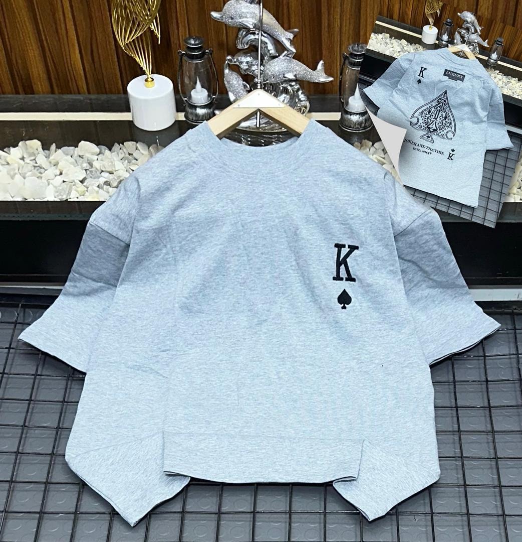 Gray oversized polo shirt with black K and spade embroidery on chest, shown on hanger with back design inset.