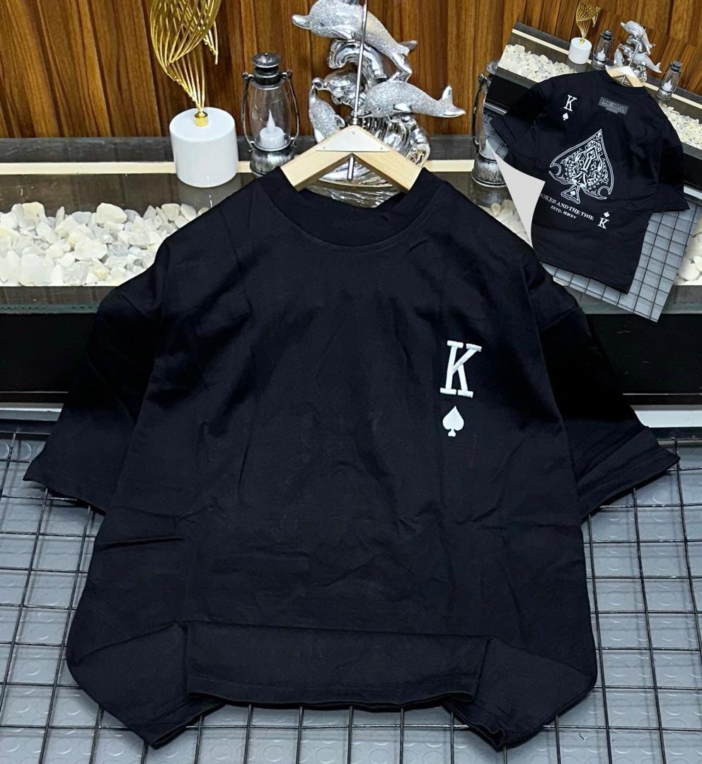 Black oversized polo shirt with white K and spade embroidery on chest, shown on hanger with back design inset.