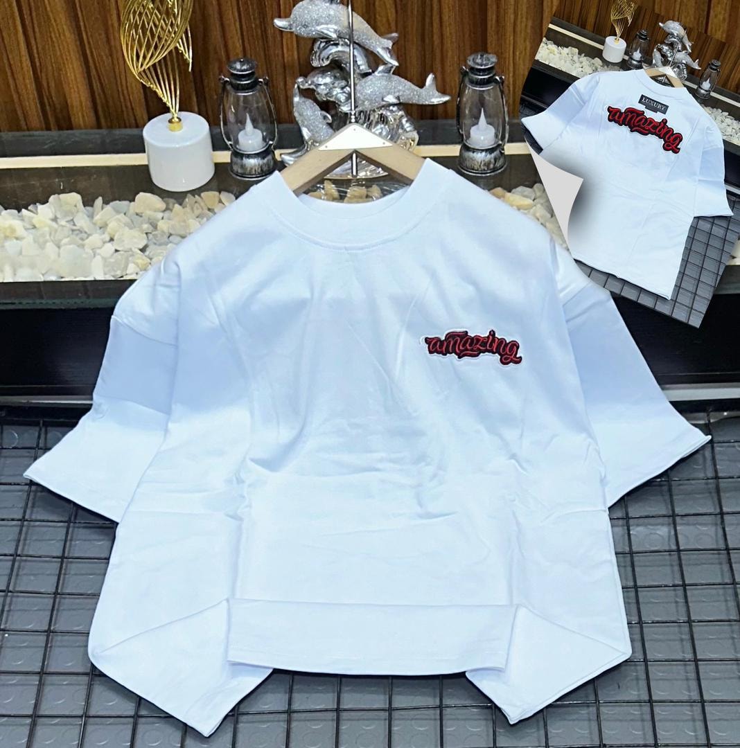 White oversized polo shirt with red amazing embroidery on the chest, shown on hanger with back view inset.