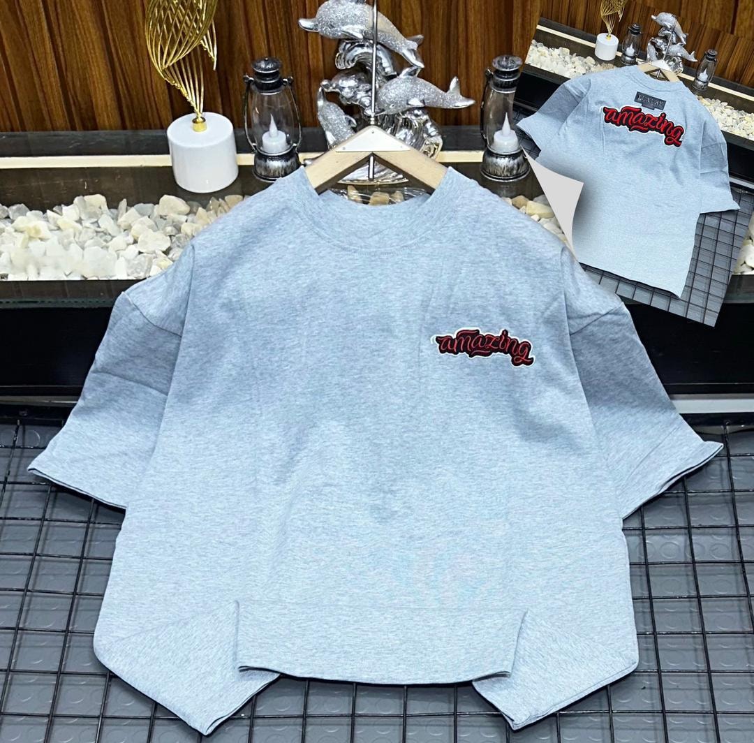 Light gray oversized polo shirt with red amazing embroidery on the chest, shown on hanger with back view inset.