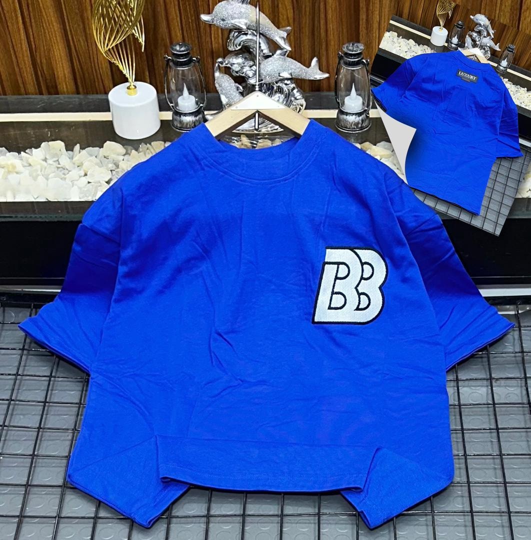 Blue oversized polo shirt with BB embroidery on the chest, shown on hanger with back view inset.