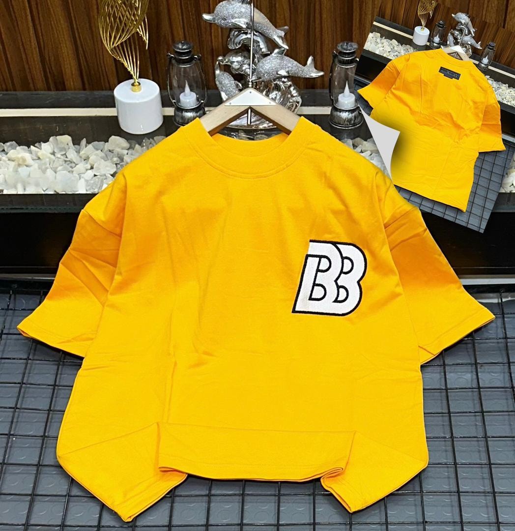 Yellow oversized polo shirt with BB embroidery on the chest, shown on hanger with back view inset.