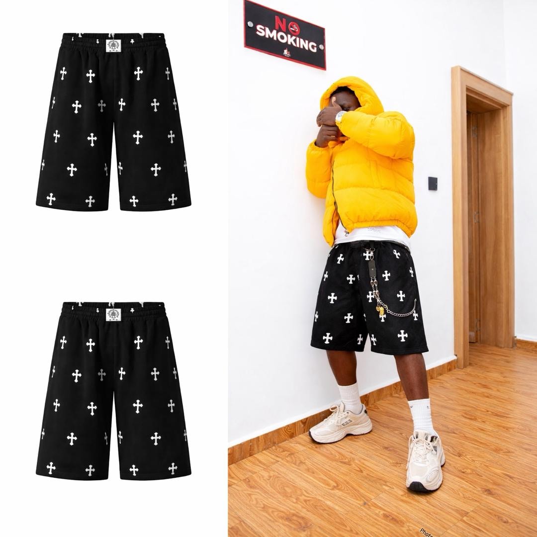 Black cross print shorts in flat lay views and worn by model with yellow jacket.