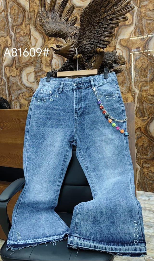 Blue baggy flared jeans with silver grommets, colorful beaded chain, displayed with eagle statue.