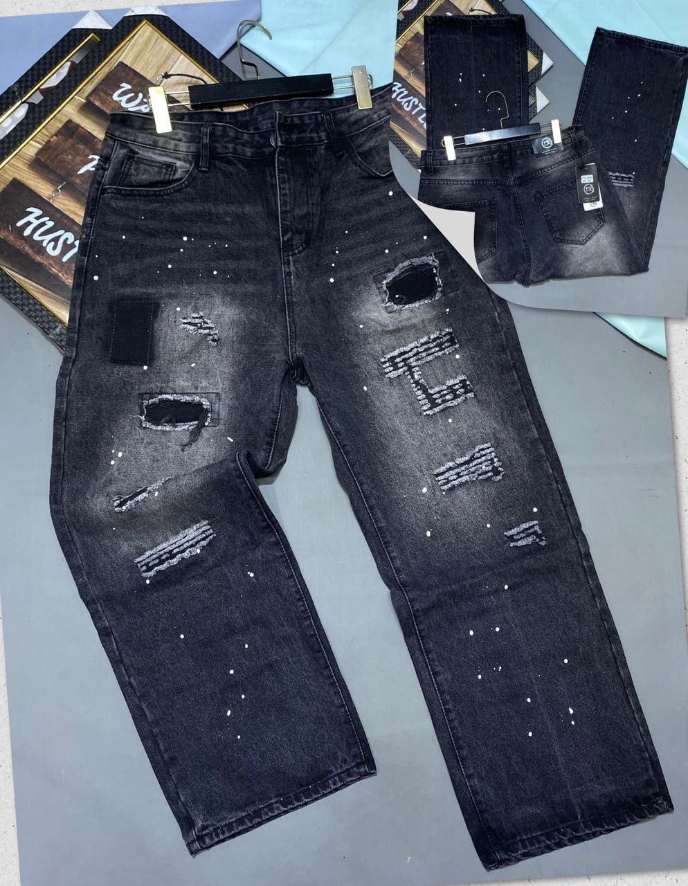 Distressed black baggy jeans with white splatters, rips, and leg graphics, front and back views.