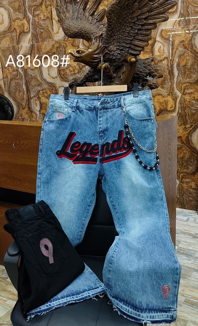 Blue baggy jeans with Legends text embroidery, chain accessory and number 9 details.