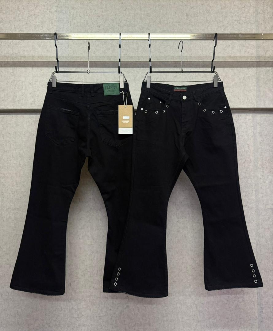 Two pairs of black flared jeans hanging side by side, right pair with visible eyelet accents.