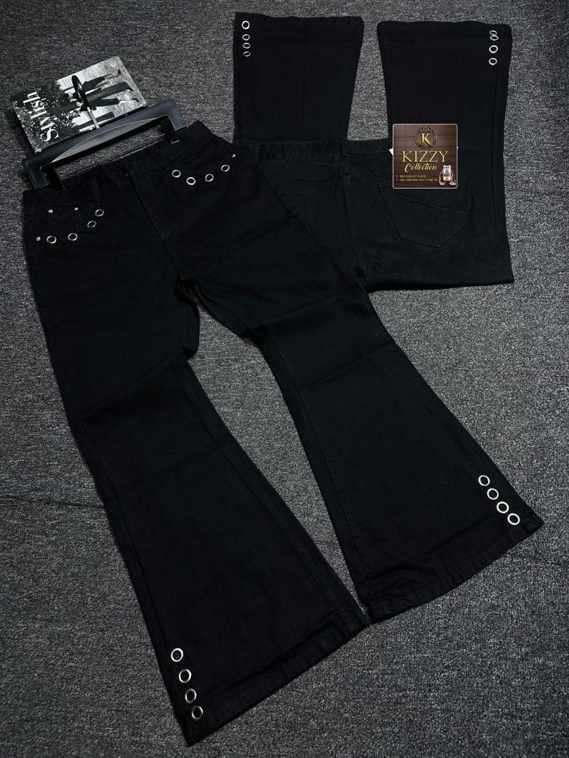 Flat lay view of black flared jeans with eyelet details on legs and waist plus KIZZY Collection tag.