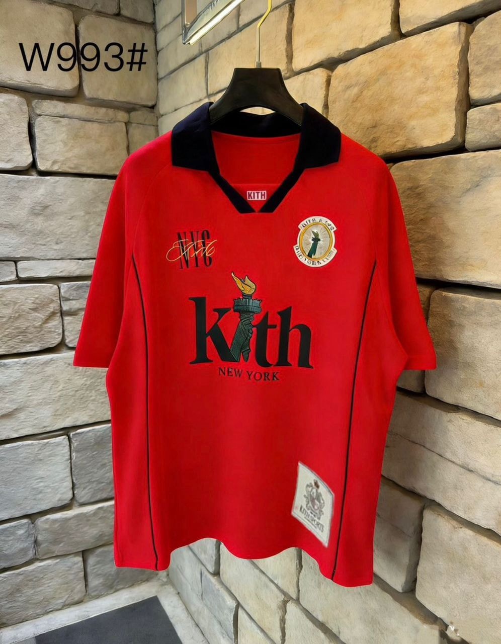 Red Kith graphic V-neck tee with black collar and piping.