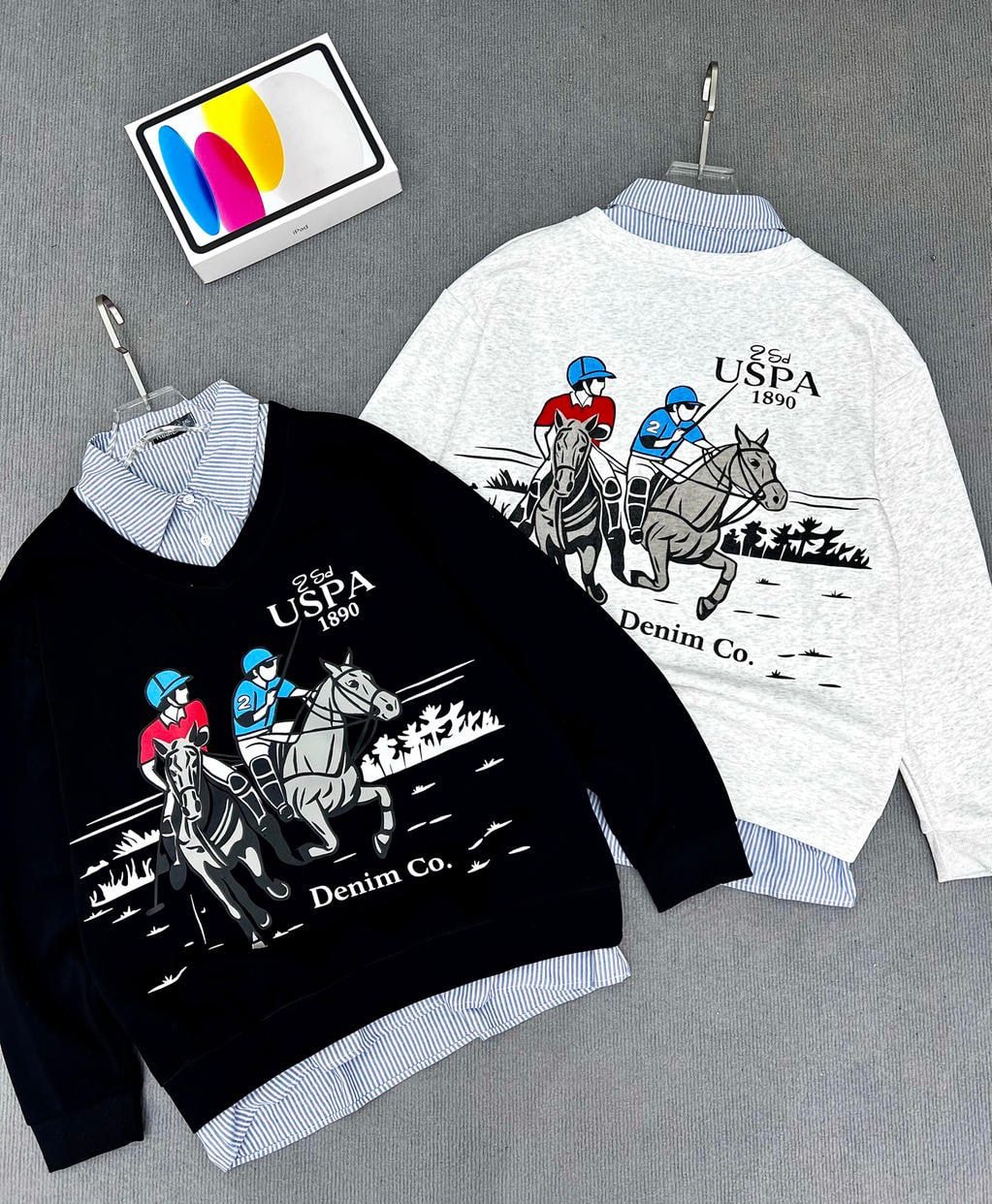 Black and white sweatshirts with USPA 1890 horse polo player graphics, layered with striped shirts.