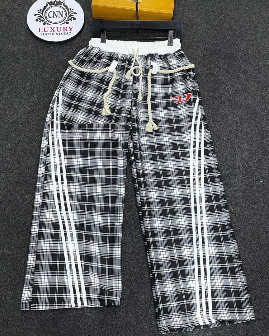 Black and white plaid joggers with triple white side stripes and adjustable waist.