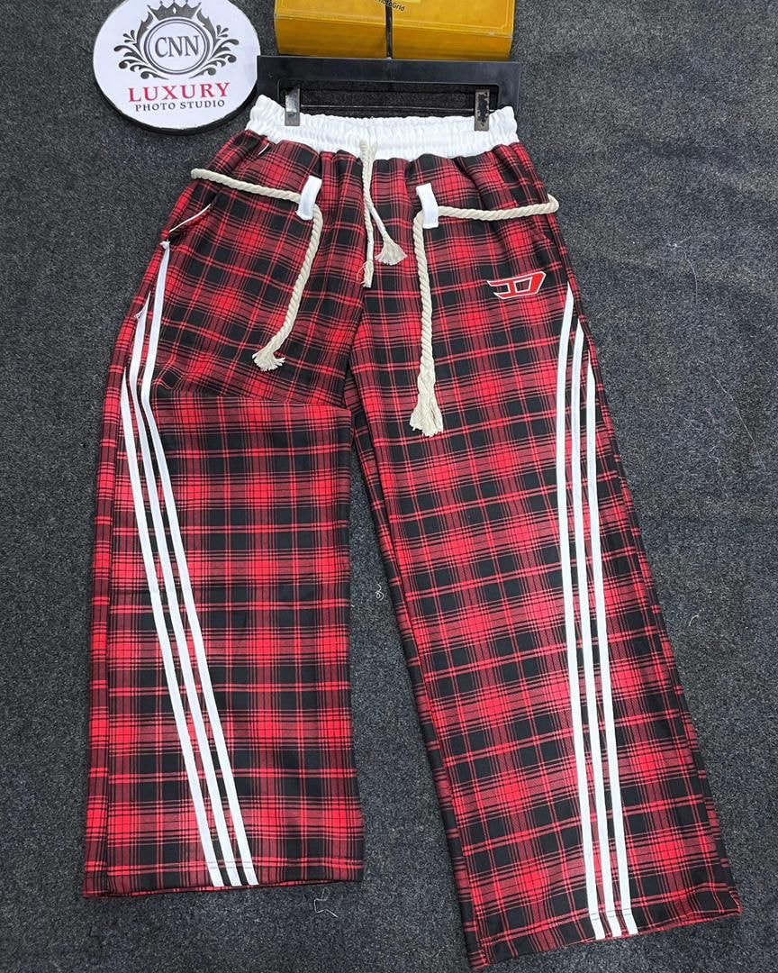 Red and black plaid joggers with white side stripes, rope drawcord and red logo.
